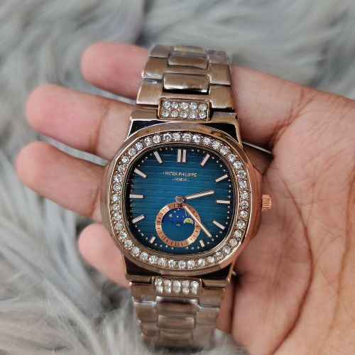 Sophisticated Patek Philippe Nautilus ladies’ watch in rose gold with diamond-set bezel, bracelet links, and blue moonphase dial.