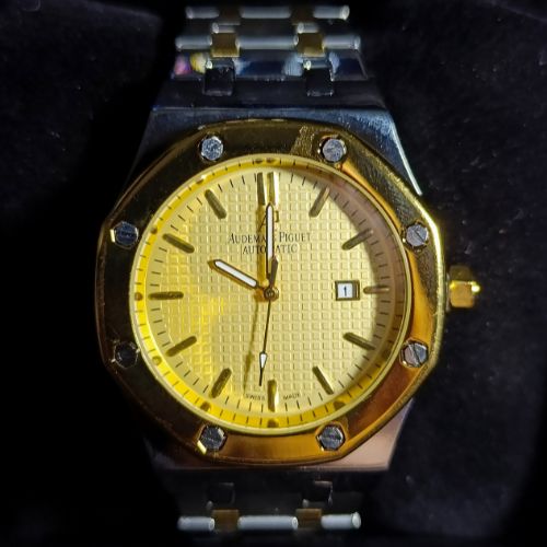 Luxury Audemars Piguet Royal Oak men’s watch with two-tone stainless steel and gold bracelet, yellow patterned dial, and date display.