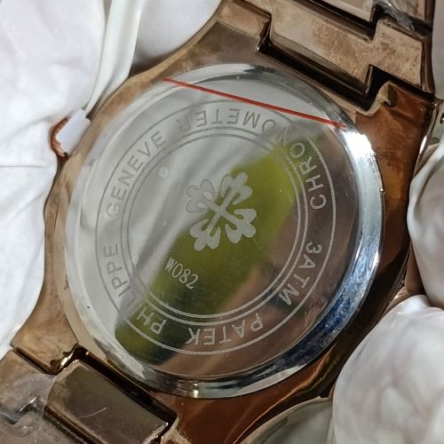 High-end Patek Philippe Nautilus rose gold women’s watch with blue dial, moonphase subdial, and sparkling diamonds.