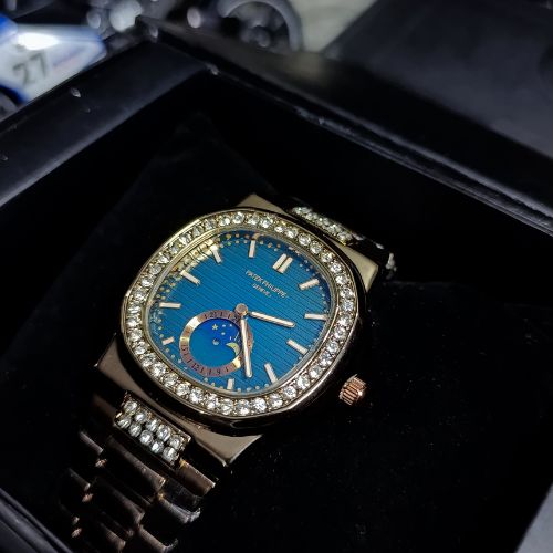 Elegant Patek Philippe women’s Nautilus watch featuring rose gold bracelet, diamond accents, and a deep blue dial.