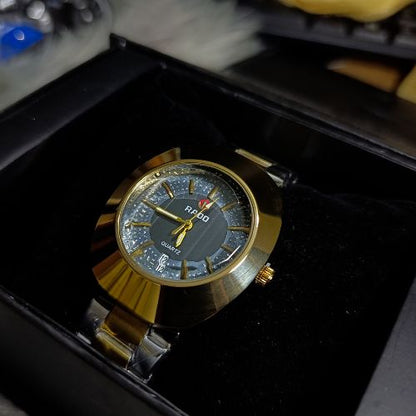 Classic Rado DiaStar men’s quartz watch featuring gold-toned case, black dial, and durable stainless steel strap.