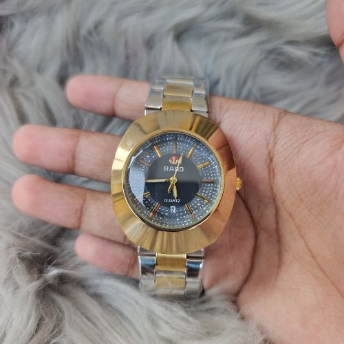 Elegant Rado DiaStar quartz men’s wristwatch featuring gold-tone stainless steel chain and classic black dial design.