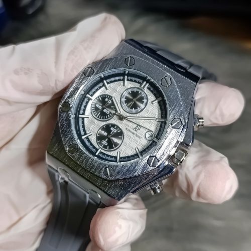 Close-up of white tapisserie dial with luminous hands and functional sub-dials