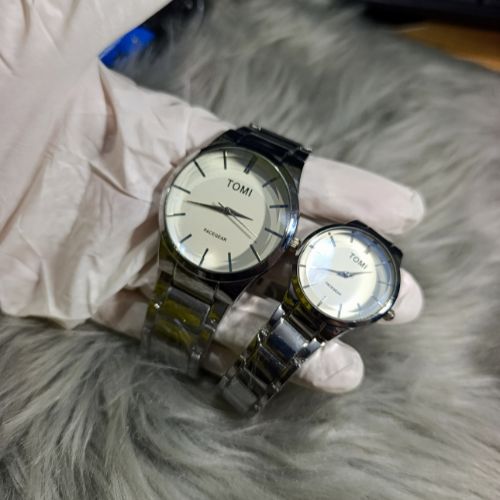 Elegant TOMI couple watch set with silver stainless steel straps, minimalist white dial, and matching his & hers design.
