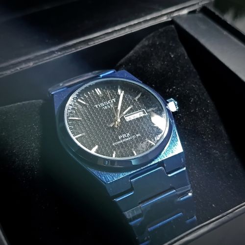 Close-up of black textured dial on Tissot PRX 1853 all blue men’s quartz watch